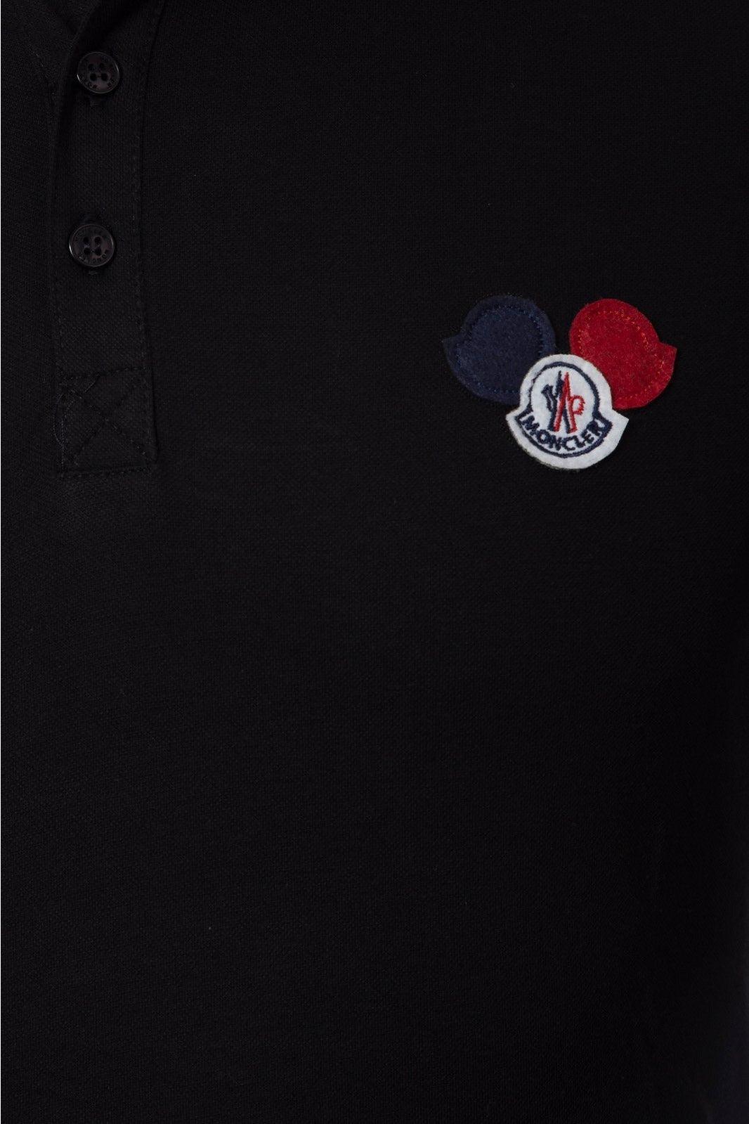 Black Moncler polo shirt with embroidered logo patch featuring blue, white, and red design